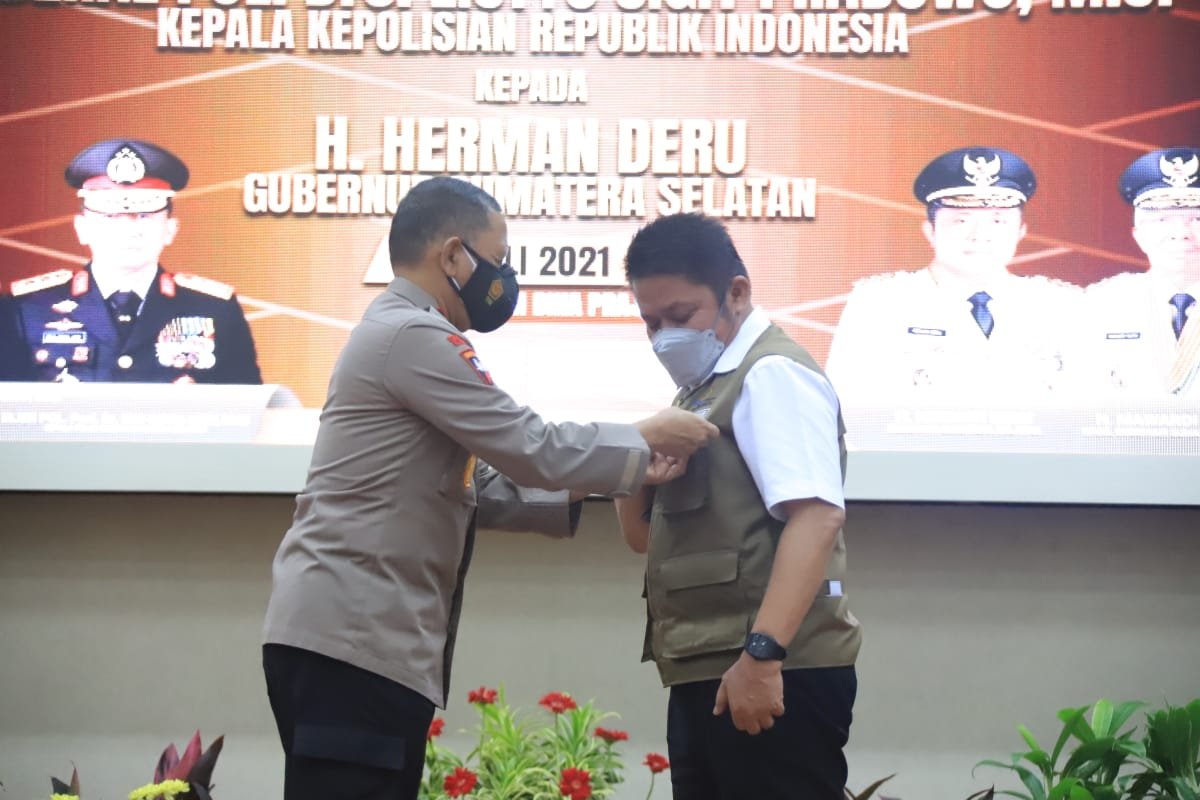 Penyematan pun emas oleh Kepala Kepolisian Republik Indonesia (Kapolri) Jenderal Pol Listyo Sigit Prabowo, melalui Kapolda Sumsel Irjen Pol Eko Indra Heri kepada Gubernur Sumsel H.Herman Deru, di Auditorium Bina Praja, Senin (5/7/2021)
