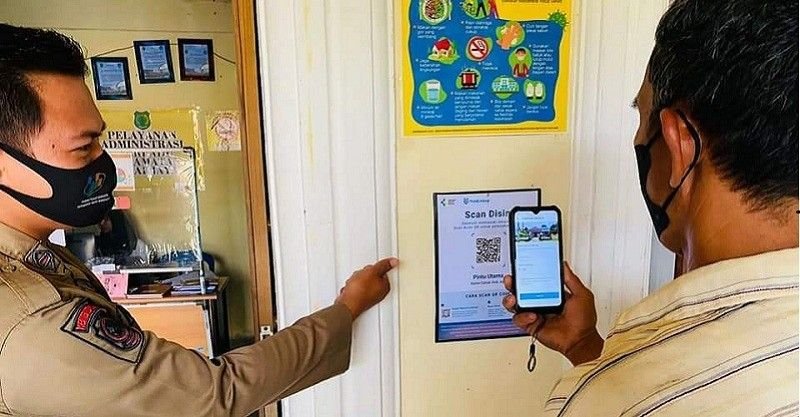 Salah satu masyarakat saat mengakses Barcode PeduliLindungi di kantor Camat Jirak Jaya kabupaten Muba