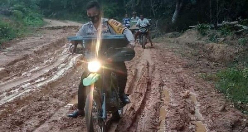 Petugas Polsek Batanghari Leko saat berjibaku menghadapi medan jalan yang berlumpur untuk mencapai ke sekateriat desa Talang Buluh