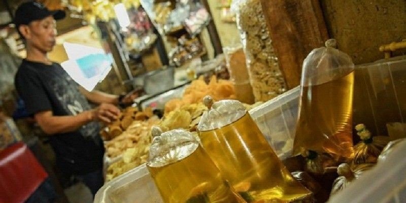 pedagang sembako tengah menjual minyak goreng curah. (foto : istimewa)