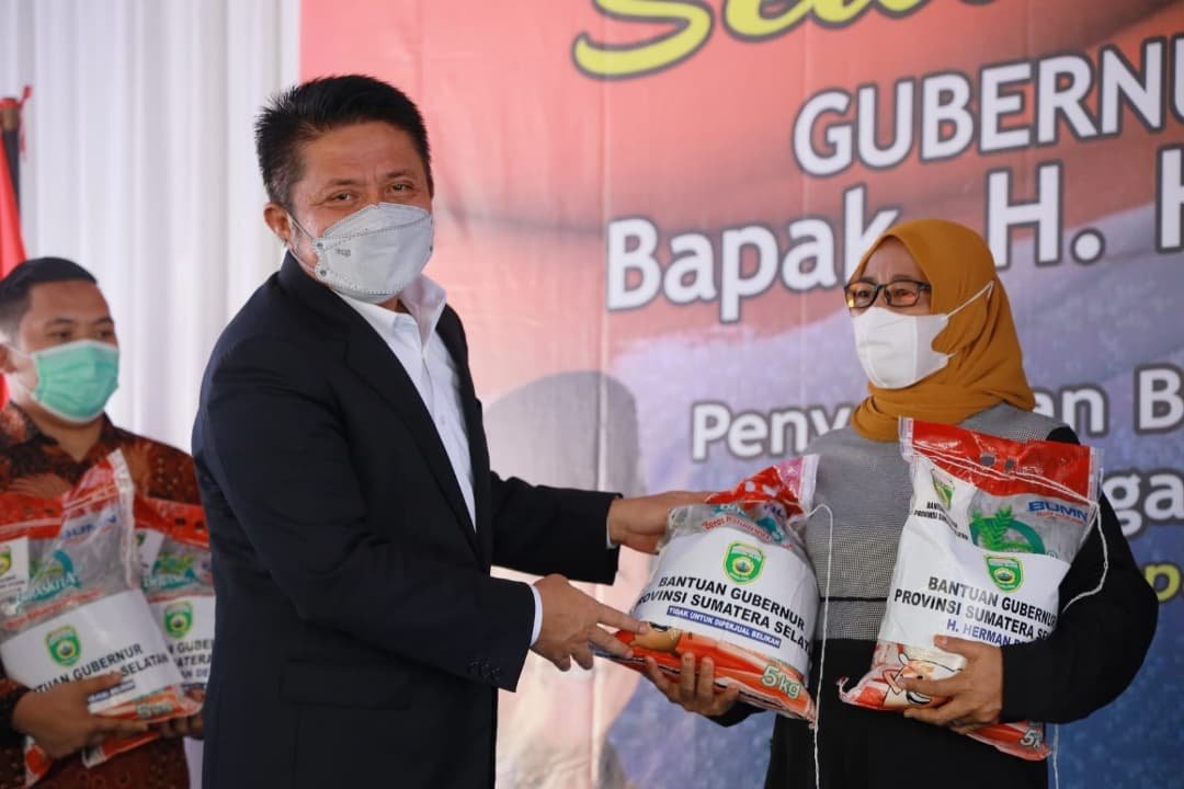 Gubernur Herman Deru saat membagikan beras kepada anggota Ikatan Keluarga Komering Mengulak (IKKM) Kabupaten OKU Timur di sekolah olahraga negeri sriwijaya jakabaring Palembang, Minggu (7/11/2021).