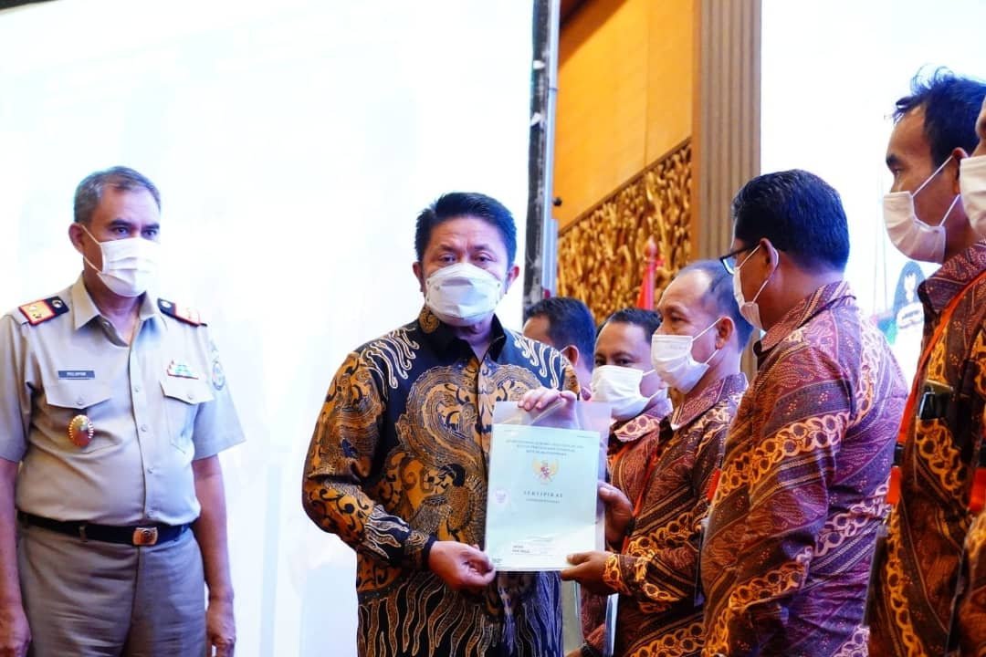 Herman Deru saat menyerahkan 15.373 sertifikat program Pendaftaran Tanah Sistematis Lengkap (PTSL) secara simbolis kepada penerima sertifikat di Ballroom Hotel Aryaduta, Selasa (14/12/2021). 