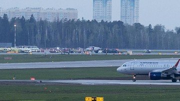 Foto: Pesawat Sukhoi SSJ-100 dari Aeroflot Airlines, tengah, terlihat setelah pendaratan darurat di bandara Sheremetyevo di Moskow