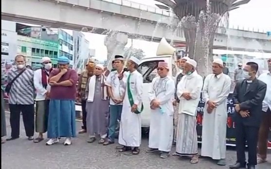 Puluhan massa dari Forum Umat Islam menggelar aksi damai di bundaran air mancur di depan Masjid Agung Palembang Jumat, (18/3)