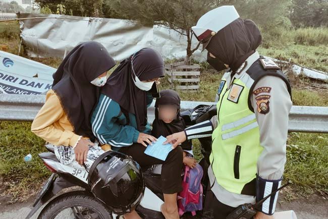 Petugas Satlantas saat memberikan surat tilang kepada pengendara sepeda motor yang melakukan pelanggaran.