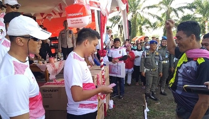 Bupati Ogan Ilir, Panca Wijaya Akbar, memberikan uang tunai kepada pemenang pertama Lomba Panjat Pinang di Lapangan KPT Tanjung Senai, Senin (22/8).-