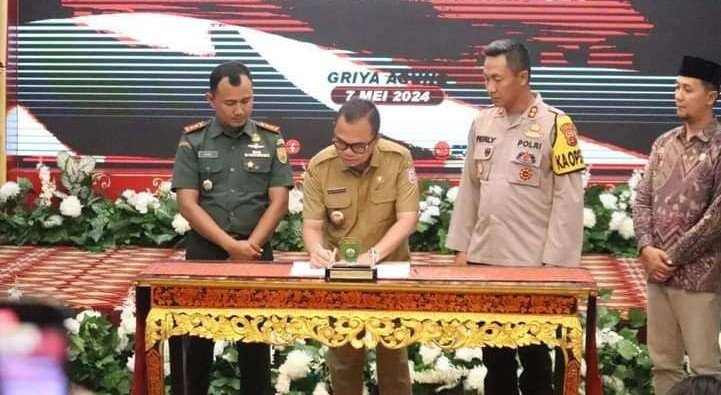 Pj. Bupati Banyuasin, H. Hani Syopiar Rustam, S. H (tengah) saat menandatangani Naskah Perjanjian Hibah Daerah (NPHD) bersama dengan TNI dan Polri, Selasa (7/5/2024). (Foto : Dok/Pemkab Banyuasin).