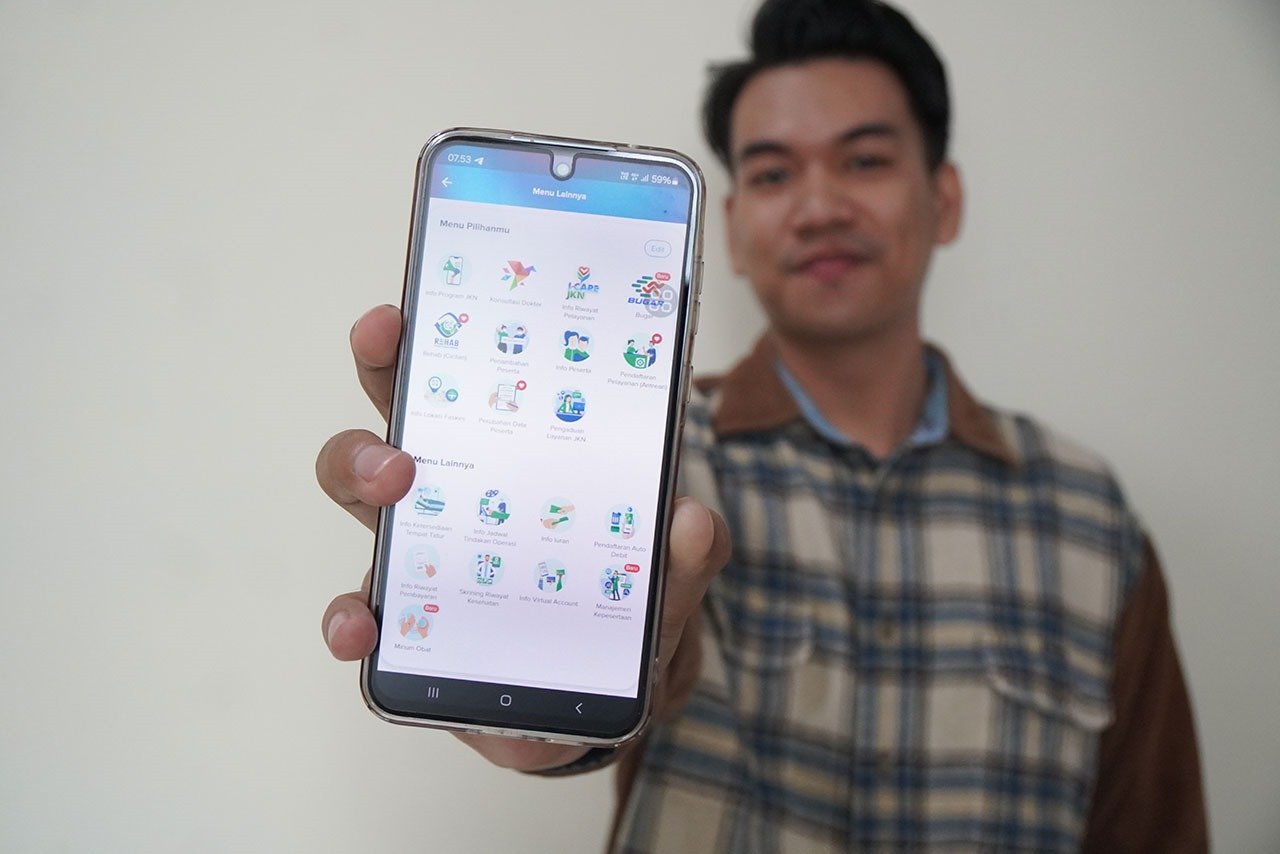 Ilustrasi seorang menunjukkan Aplikasi Mobile JKN. (Foto: BPJS Kesehatan)
