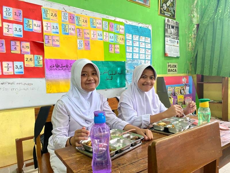 Dua siswi SDN Kotagede 3 sangat antusias ketika mereka mendapatkan makanan dari Program MBG. (Foto : Dindikpora Yogya)