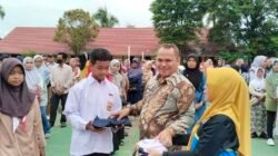 Kepala Sekolah SMP N 12 Palembang, Suparman Sunaryo, S.Pd., M.Pd saat menyerahkan seragam sekolah gratis bantuan dari Walikota Palembang kepada siswa secara simbolis