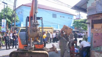 Satuan Polisi Pamong Praja Kota Palembang membongkar rumah dan kios di Jalan Puncak Sekuning, di dekat SMA Negeri 2, Rabu (26/11/2025)