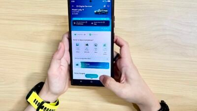 Pelanggan saat menggunakan aplikasi PLN Mobile untuk memantau kondisi antrean di lokasi SPKLU sebelum melakukan pengisian daya kendaraan listrik.